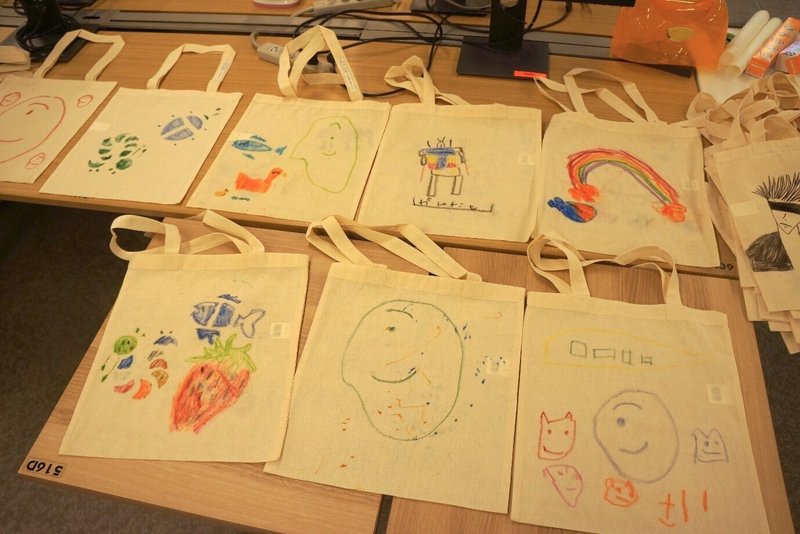 子どもたちがそれぞれに好きなイラストを描いたトートバッグが複数並んだ写真