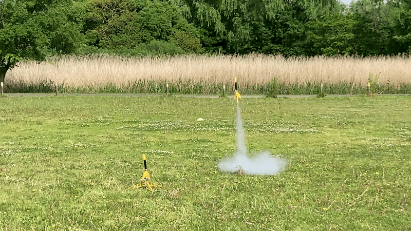 モデルロケットの打ち上げの瞬間、下部から煙を出しながらロケットが上昇している