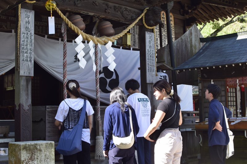 温泉神社でみんなが参拝している様子