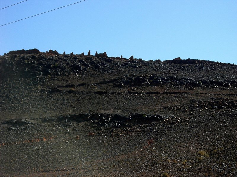 黒い礫山の頂上に崩れた砦の痕跡が見える