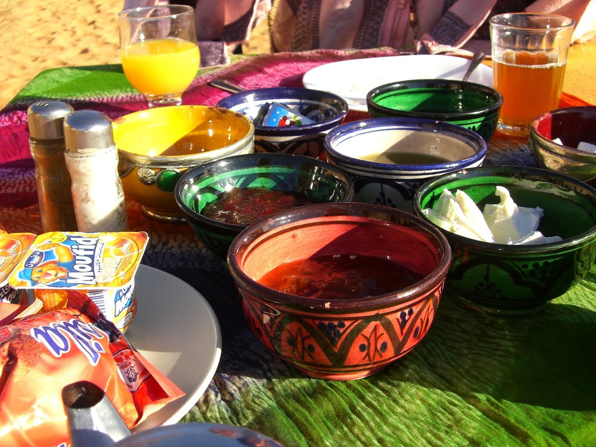 テーブルの上に小皿や調味料、ヨーグルト、オレンジジュースなどが置かれている