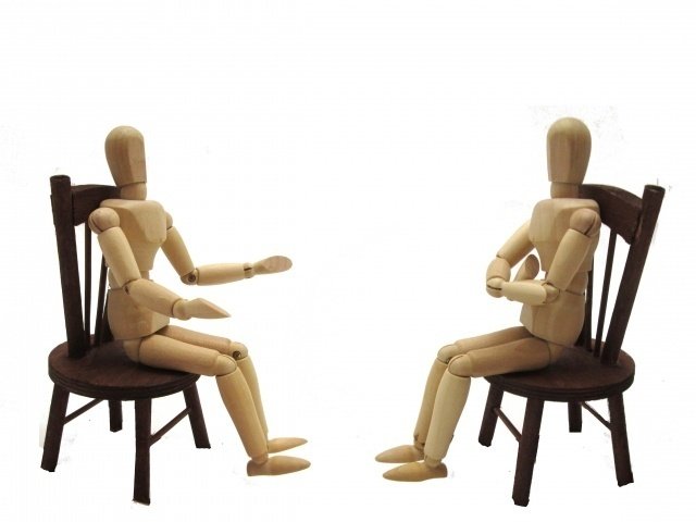 椅子に座って向かい合っている木製人形