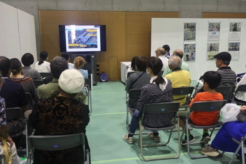 昭島矯正展で映像を見る一般来場者たち