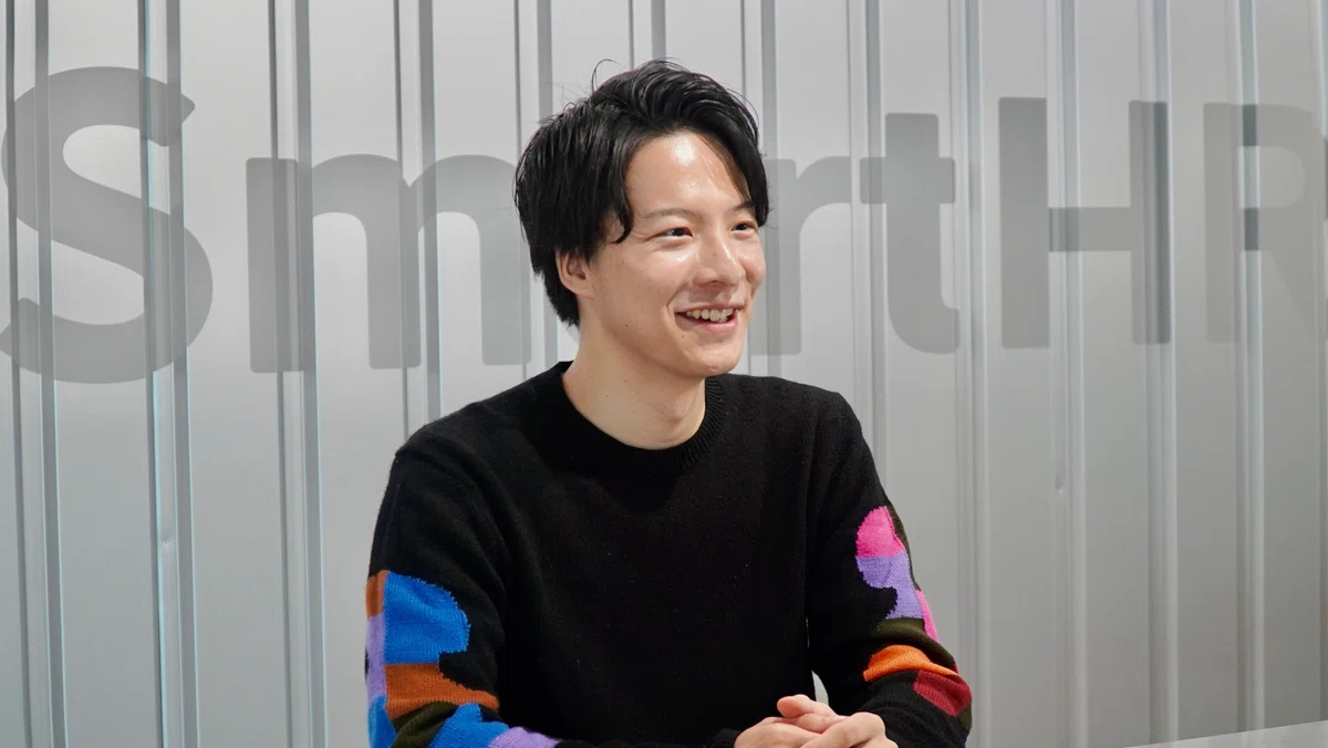 右を向いて話す男性の横顔。