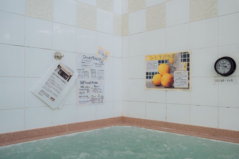 小杉湯の浴室内の写真。壁にラミネートされたnoteの記事が掛けられている