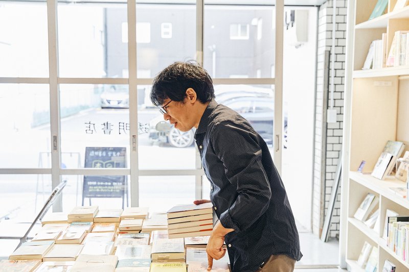 届いた本を並べる遠井店長