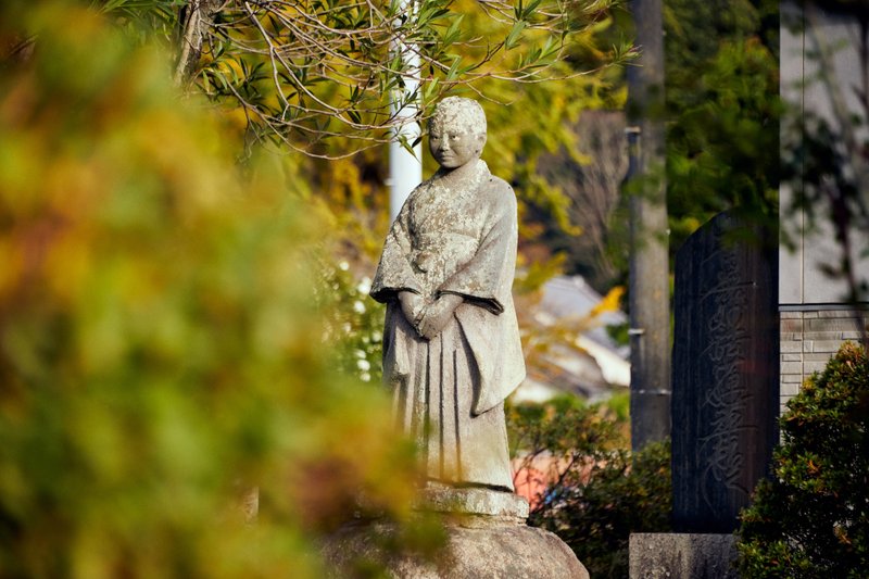 三井子さんの等身大像、前で手を重ねて佇んでいる