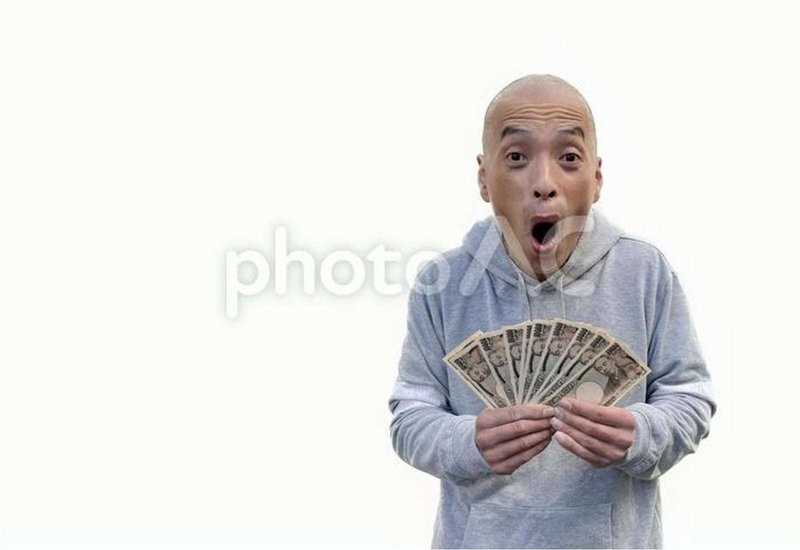 お金を持って驚く日本人男性の画像