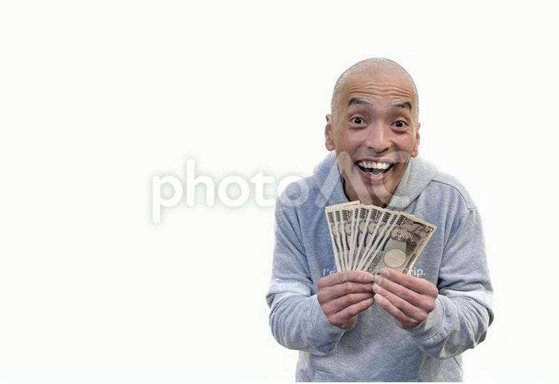 お金を持って笑う人の画像