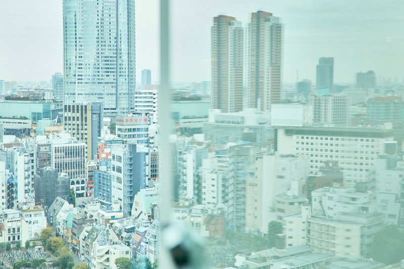 窓ガラス越しに見た六本木の高層ビル。ガラスに映り込んだ鏡像。抽象的な風景写真。