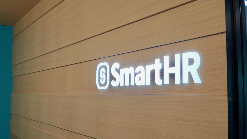 SmartHRの東京オフィスエントランスの壁の写真。右手に「SmartHR」のロゴが写っている。
