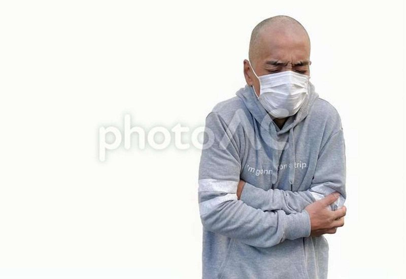 マスクをして震える日本人男性の画像