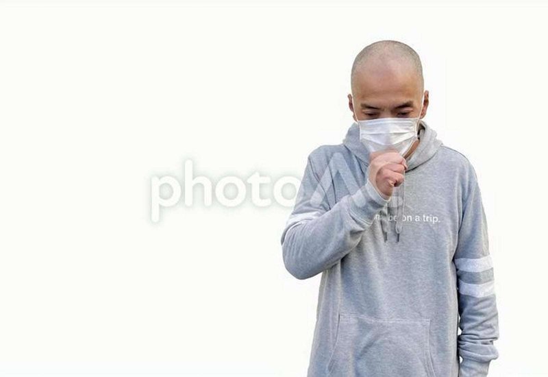 マスクをして咳をする日本人男性の画像