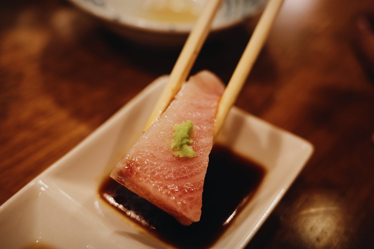 わさびを乗せたブリを醤油につける