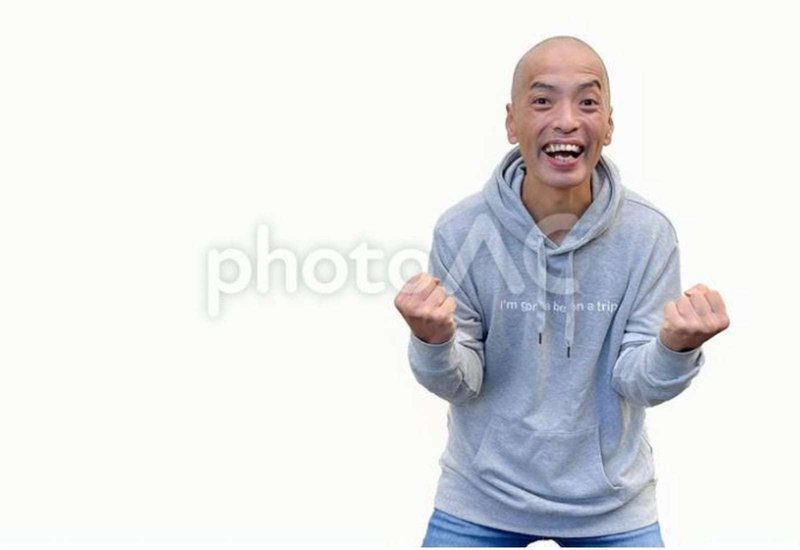 笑顔でガッツポーズをする日本人男性モデルの画像