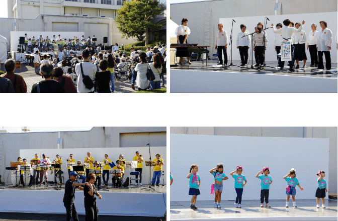 第51回横浜矯正展（2023年11月4日(土)@横浜刑務所）の会場に設営されているステージでダンスを踊る地域の子供たちと観客たち、ステージで演奏する地域の学生の吹奏楽団、合唱する地域の方々、演奏する地域のオーケストラ