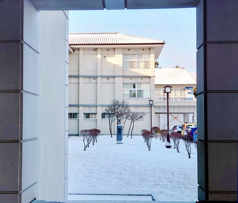 本校の正面玄関の構造は、東西の中庭を絵画に見立てるピクチャーウィンドウ様の構造があります。正面玄関の西側に設置されている宮澤賢治像が雪の中に佇んでいます。