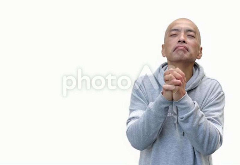 両手を握って祈る中年日本人男性モデルの画像