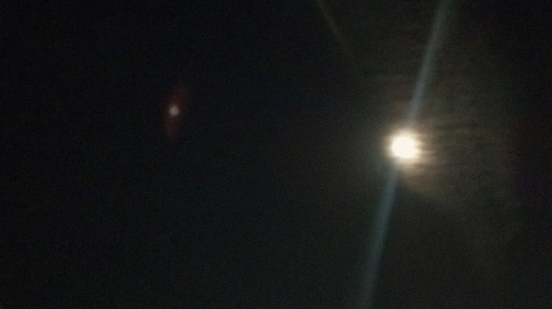 赤い光の玉（カメラのゴースト）と月が光る夜空