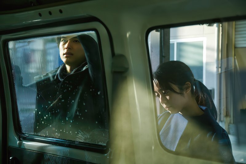 場面写真　山添くんと藤沢さんが並んで社用車の窓を拭く。落ち込んだ表情の藤沢さん