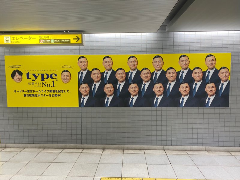 都営大江戸線 春日駅に掲出された転職サイト『type』の広告。「オードリー東京ドームライブ開催を記念して、春日駅限定ポスターを公開中！」のコピーと18人のスーツを着た春日の画像が並んでいる。