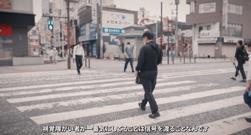 横断を歩道を渡る川田さんの画像。「視覚障がい者が一番気にしていることは信号を渡ることなんです」と話している。