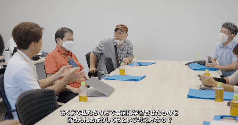 長テーブルを囲んで、Eye Naviのユーザーと座談会をする川田さんの画像。