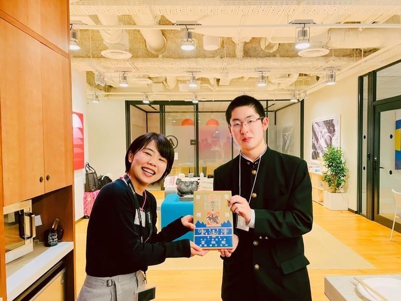 「明がらす」という遠野名物のお菓子をくれる小松平さんと受け取るnote PRの森本さんの写真