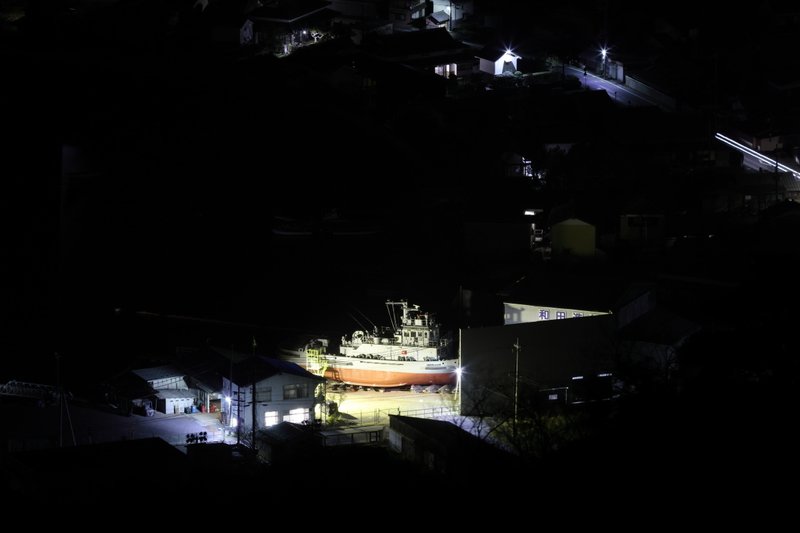 闇夜に浮かび上がる小さな造船所の船