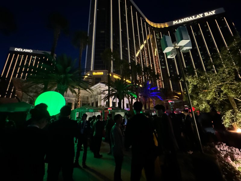 パーティー会場の様子の写真です。緑色のボールが明るく会場を照らしています。後ろにマンダレイベイと英語で書かれた巨大なホテルがあります。撮影技術が低いことが原因で、ほぼ真っ暗に写っている写真です。