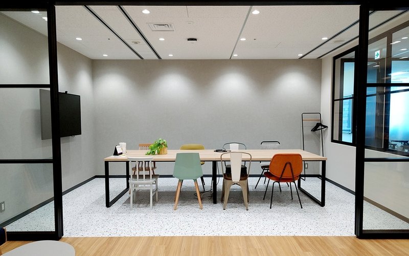 写真：ガラス張りのミーティングスペース。椅子のデザインが全て違う。