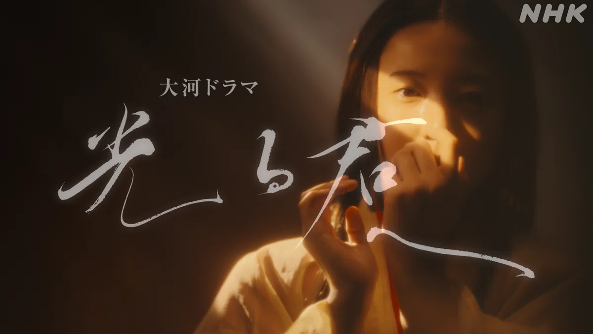 オープニング映像に「光る君へ」の題字が出ているようす。光と影の中にいるまひろが口に手を当て、何か言いたげな表情をしている。