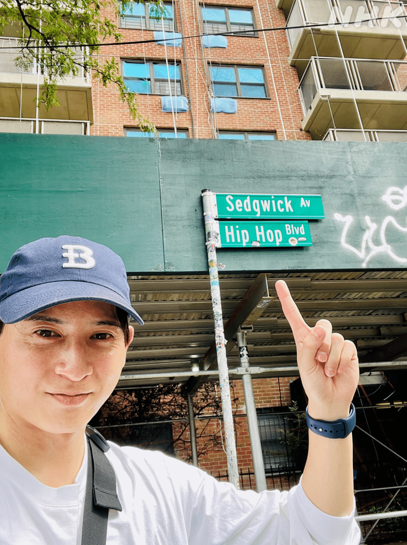 西川アナが指をさす先の看板に「Hip Hop Blvd」とある。
