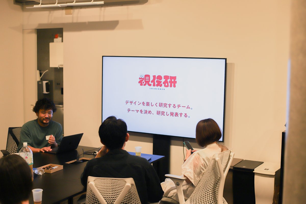 写真。登壇者の江辺さんがスライドを見せながら、「視伝研」について説明している様子。