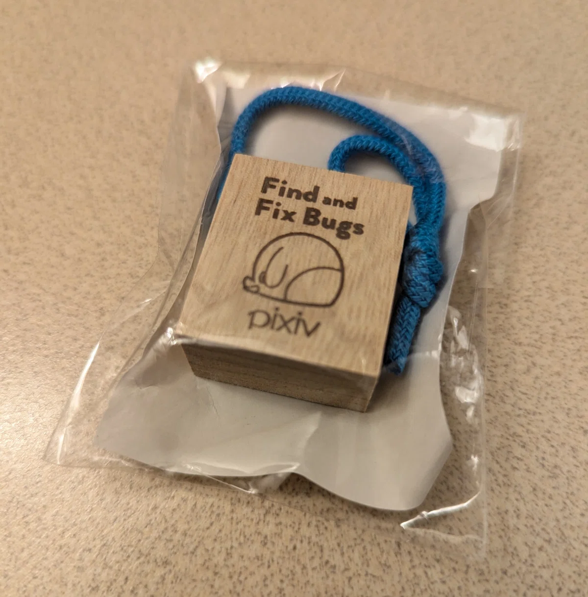 クスノキの防虫剤。表面にFind and Fix Bugsとpixivの焼き印がある