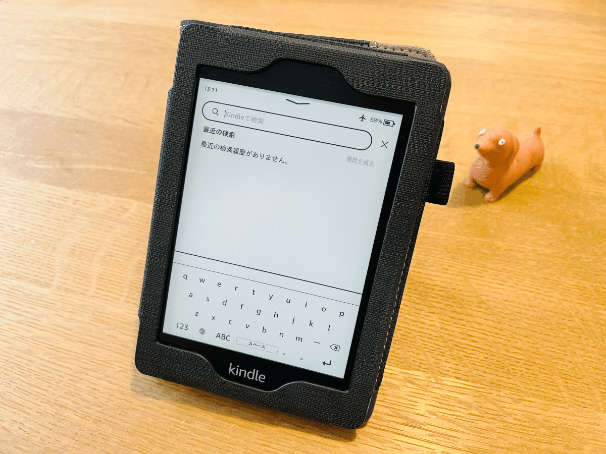 Kindle Paperwhiteがテーブルに立てて置かれ、検索画面が表示されている