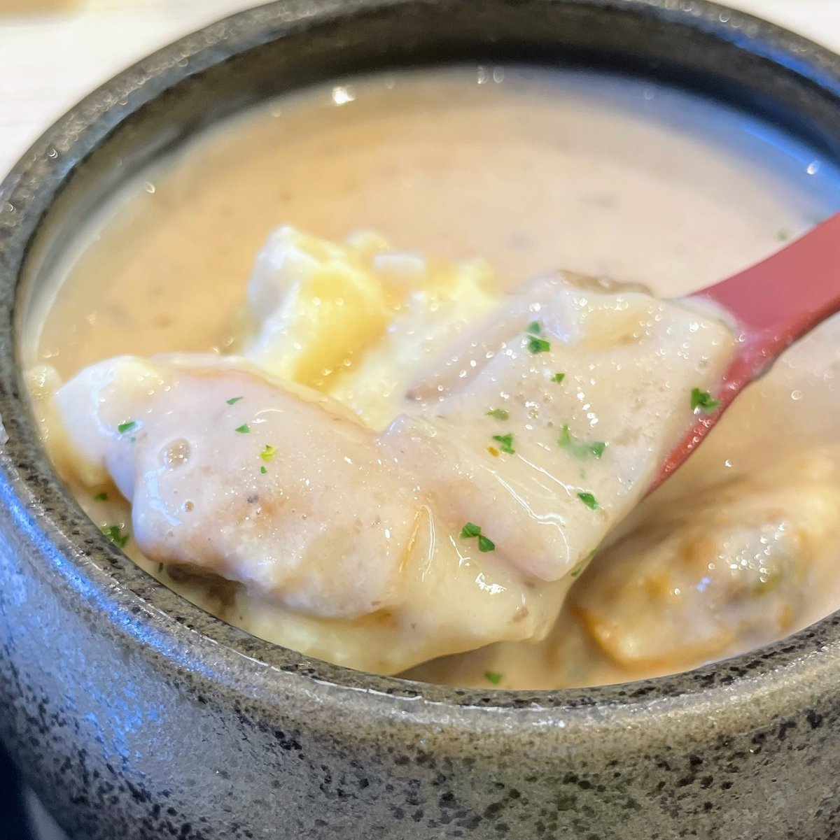 茶碗蒸しをスプーンですくった写真　エリンギとアサリっぽいものと鶏肉かなにかが見える