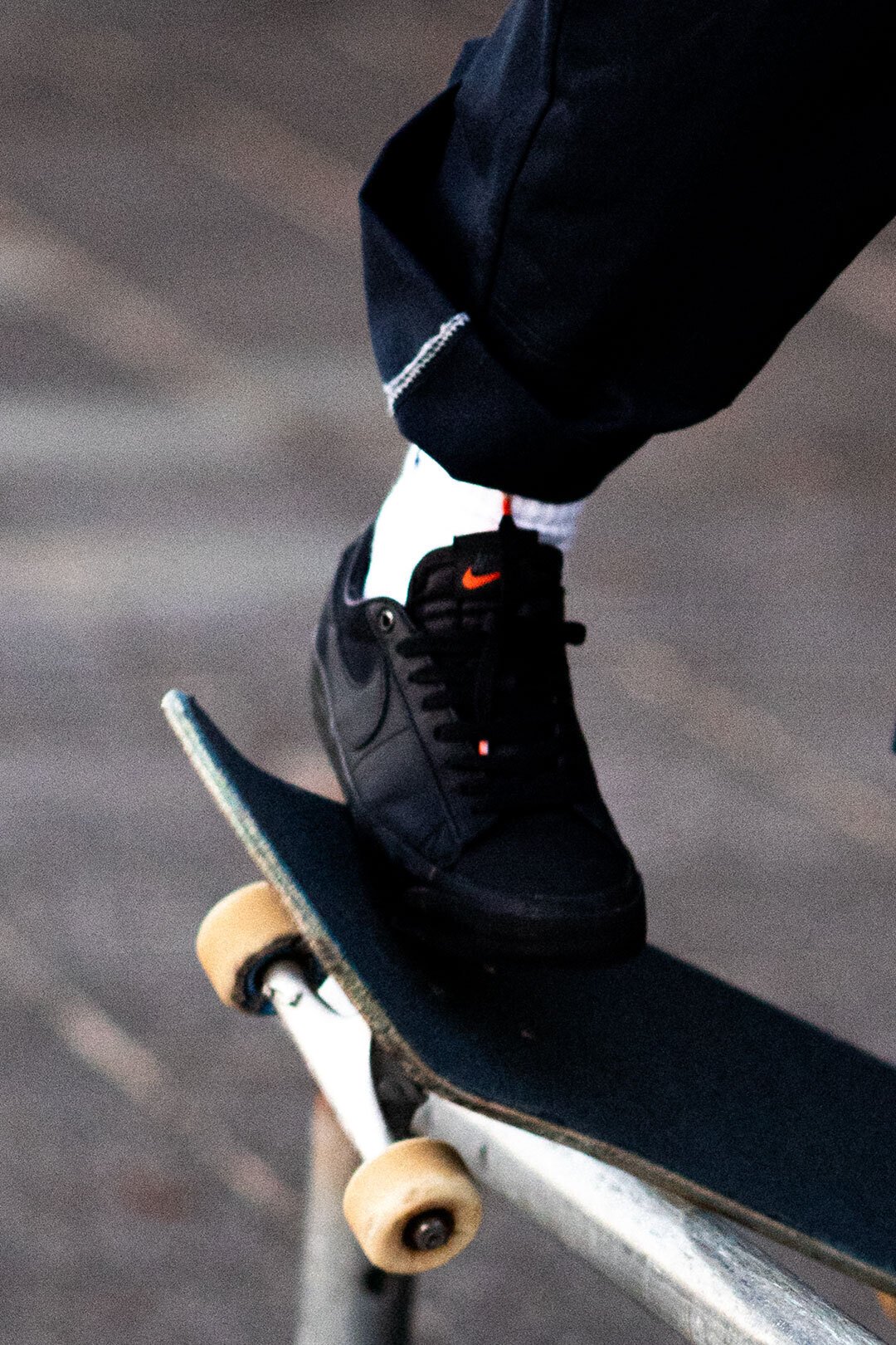 オレンジの夕日に照らされるオールブラックのNIKE SBシューズ。｜HI5