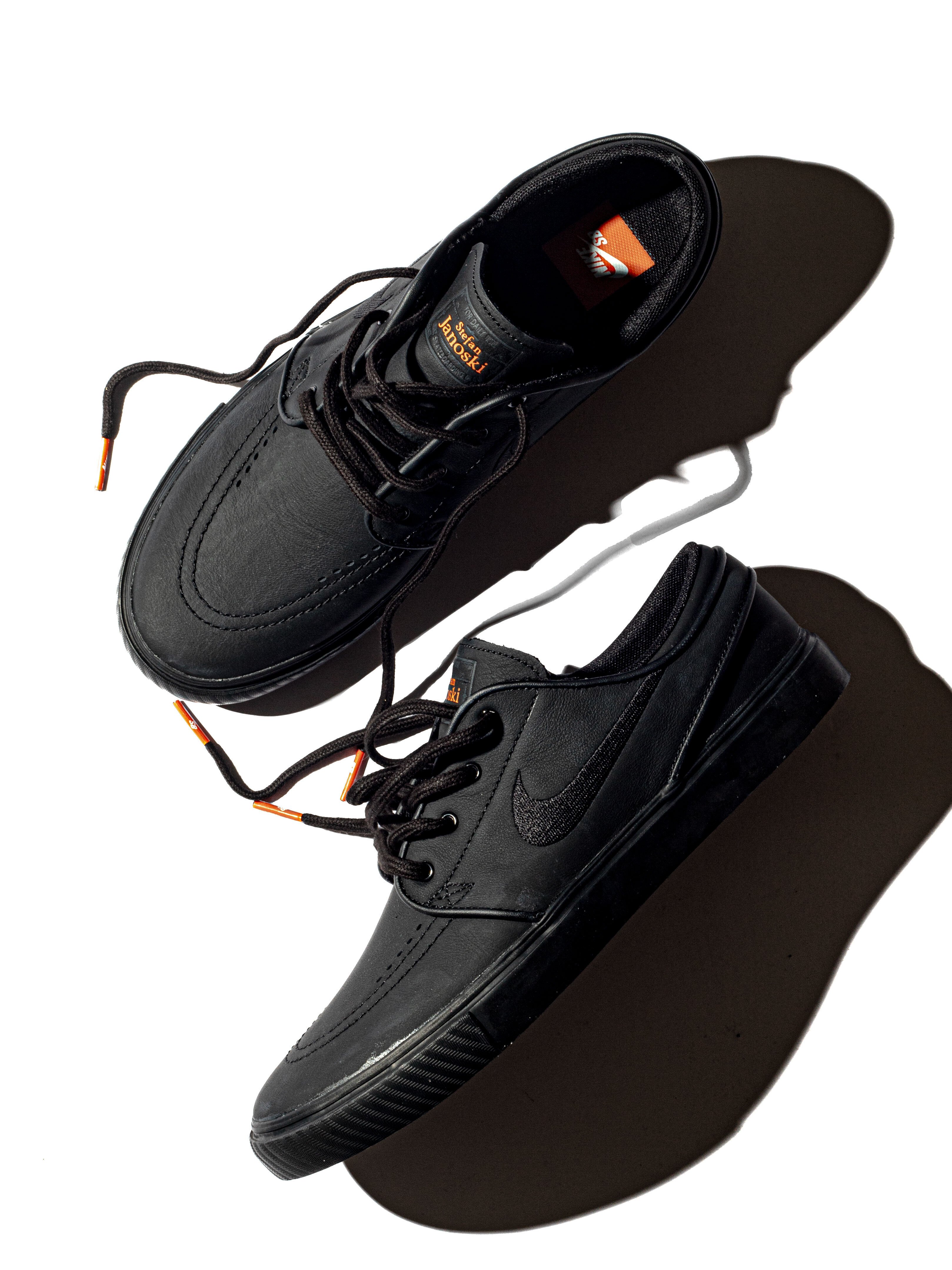 オレンジの夕日に照らされるオールブラックのNIKE SBシューズ