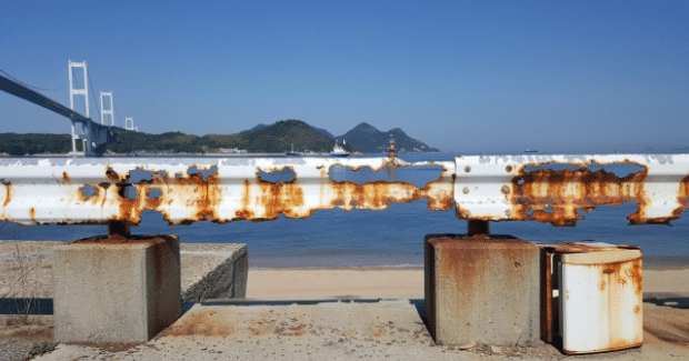 錆びて朽ちた海辺のガードレールの画像