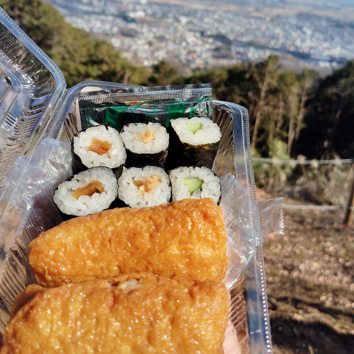 稲荷寿司と細巻きのお弁当の写真