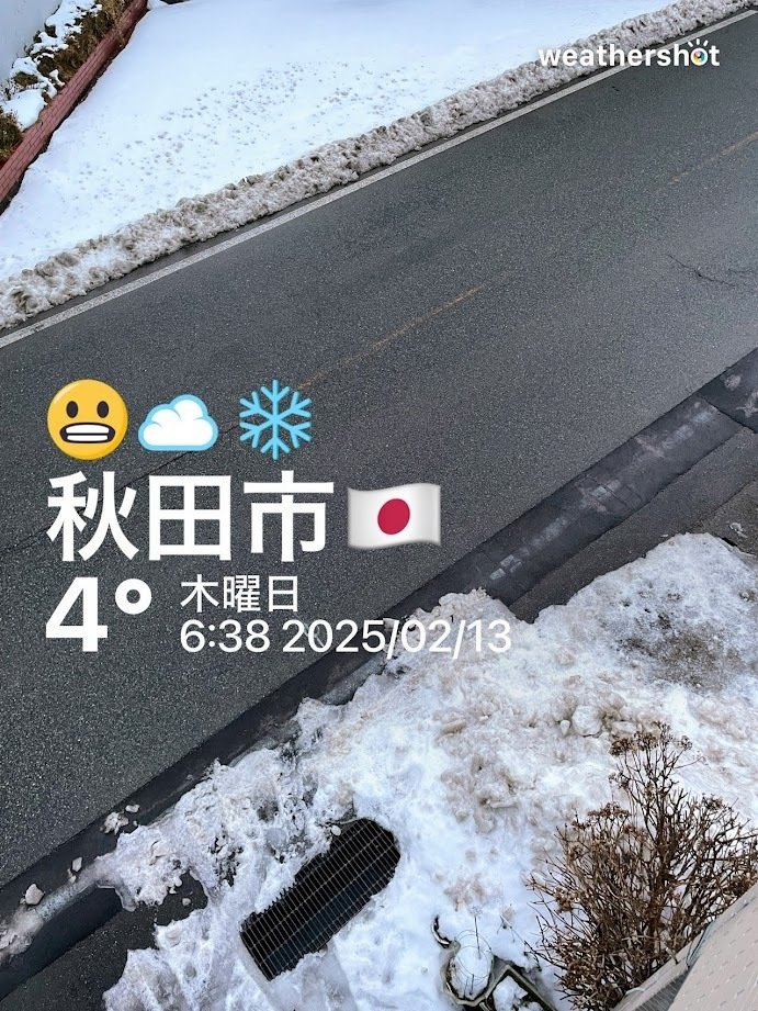 2階から道路を見下ろした写真　路面は黒く、濡れている　両脇には汚い雪がある　weathershotによる気象情報　秋田市4℃