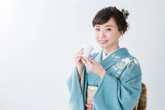 日本酒を飲む着物を着た女性