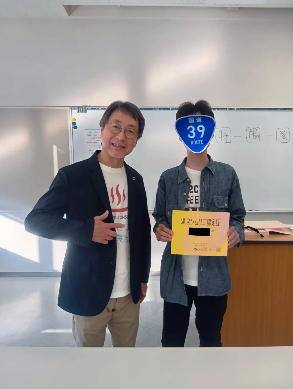 認定証を手にトムさんと撮影した記念写真
