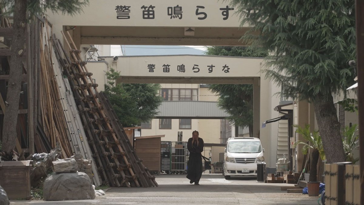 「警笛鳴らすな」の文字と新左衛門が映った舞台セット
