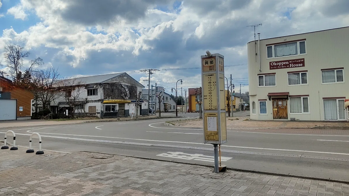 興部バス停とその背景の市街地の写真