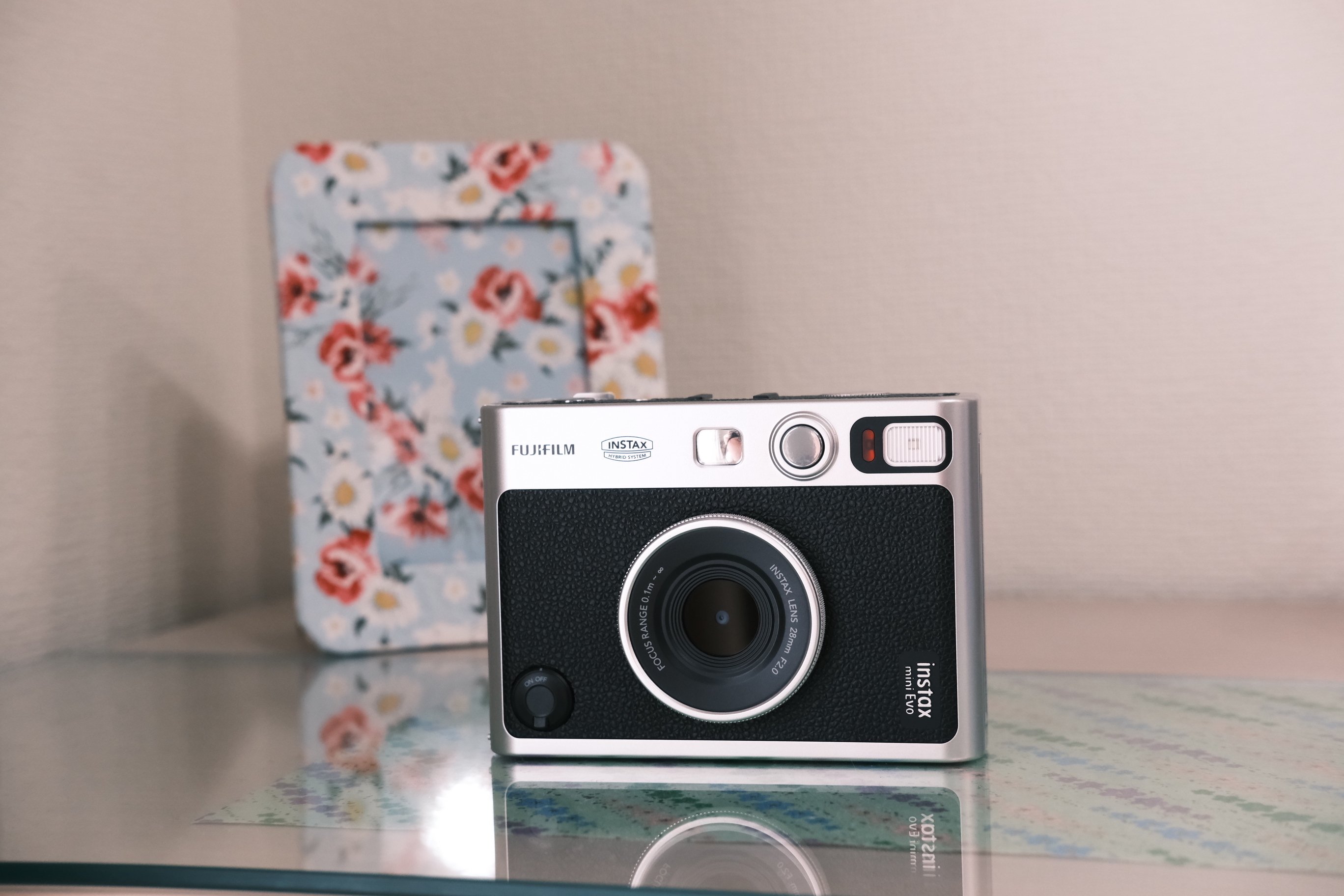 FUJIFILM instax mini Evoと写真立てが飾られている