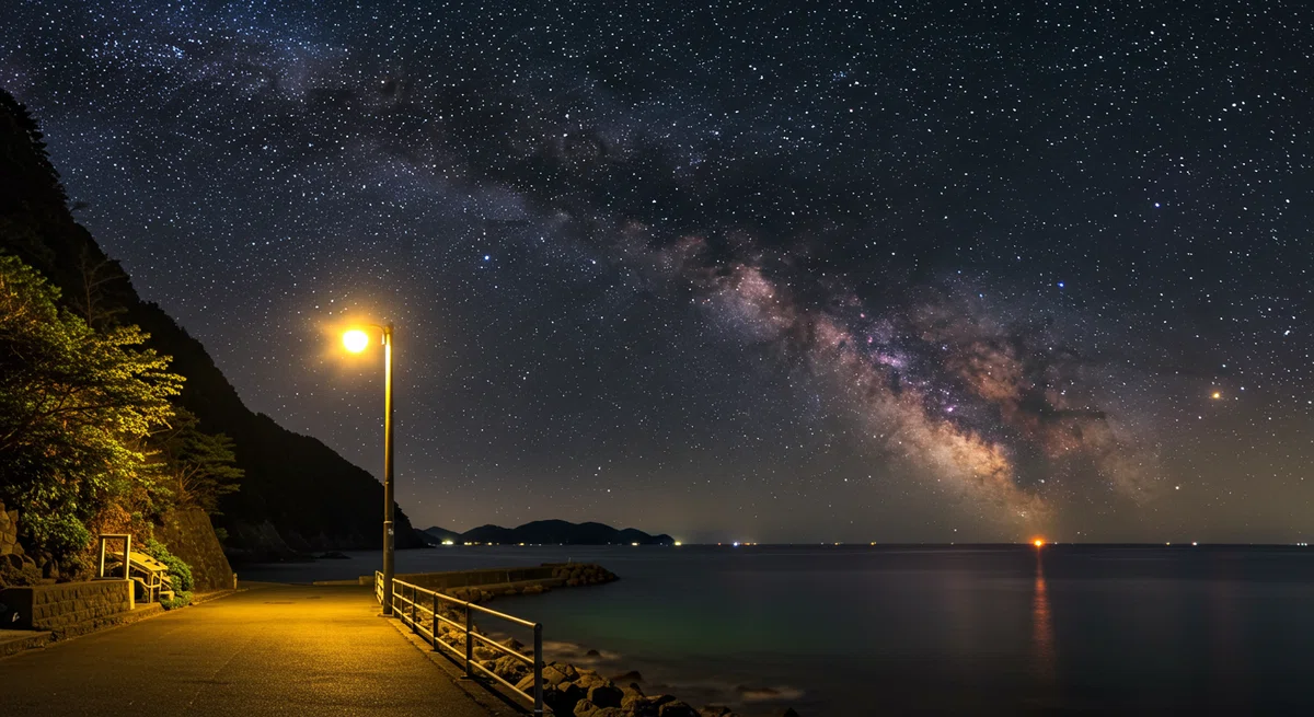 漁港の常夜灯と、その向こうに広がる満天の星空。