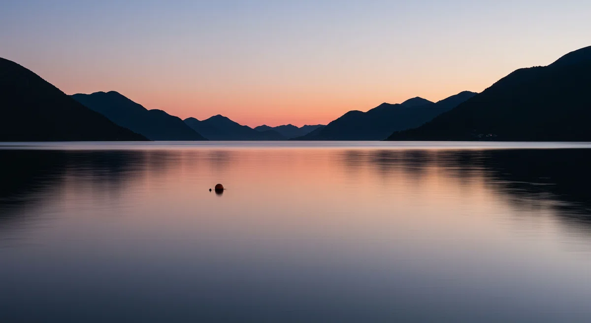 風が一切ない夕暮れの入り江。水面が鏡のように空を映し、ウキが一つだけポツンと浮かんでいる