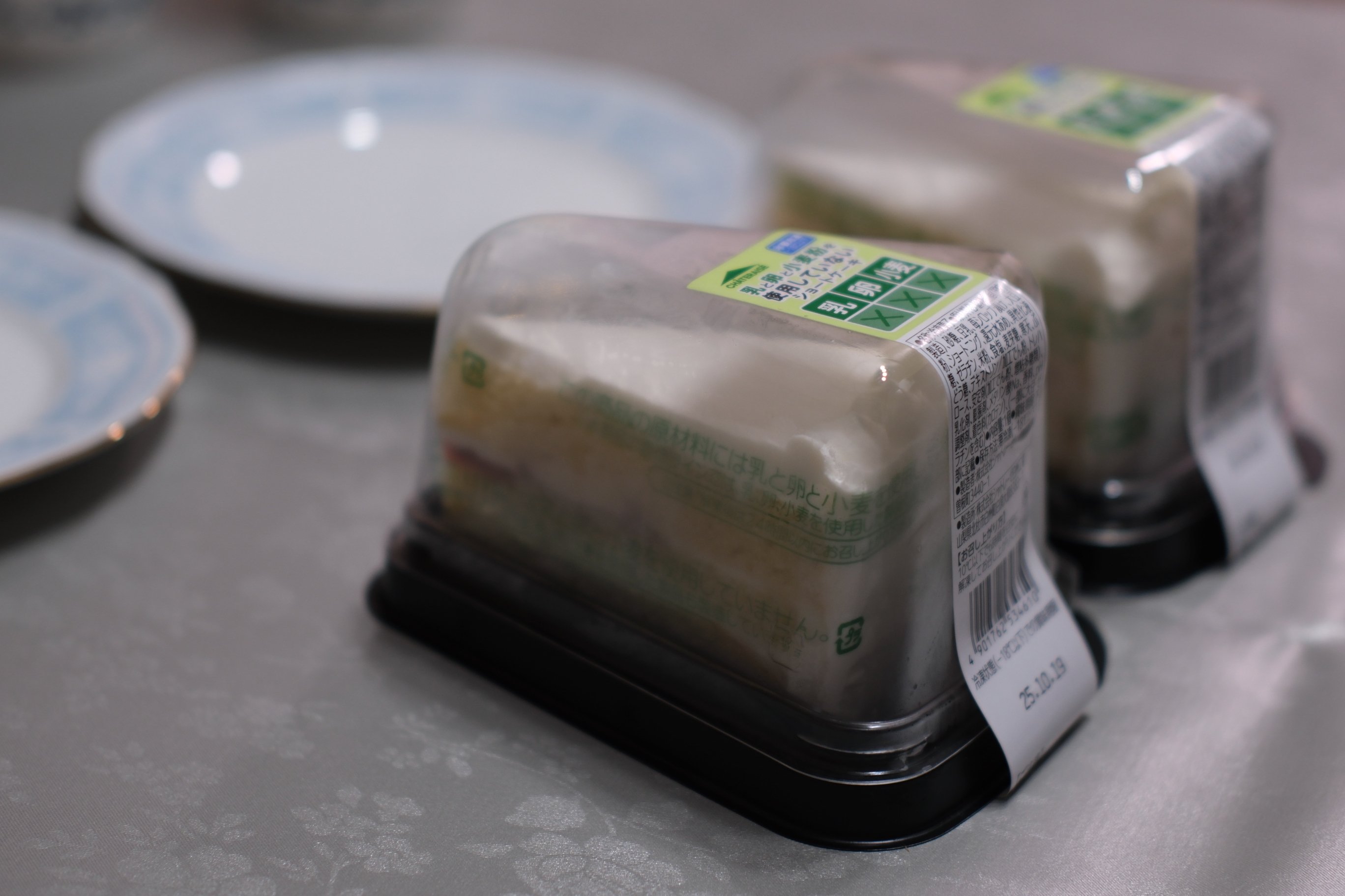 シャトレーゼの、乳と卵と小麦粉を使用していないショートケーキが2個と、ケーキ皿が並ぶ画像